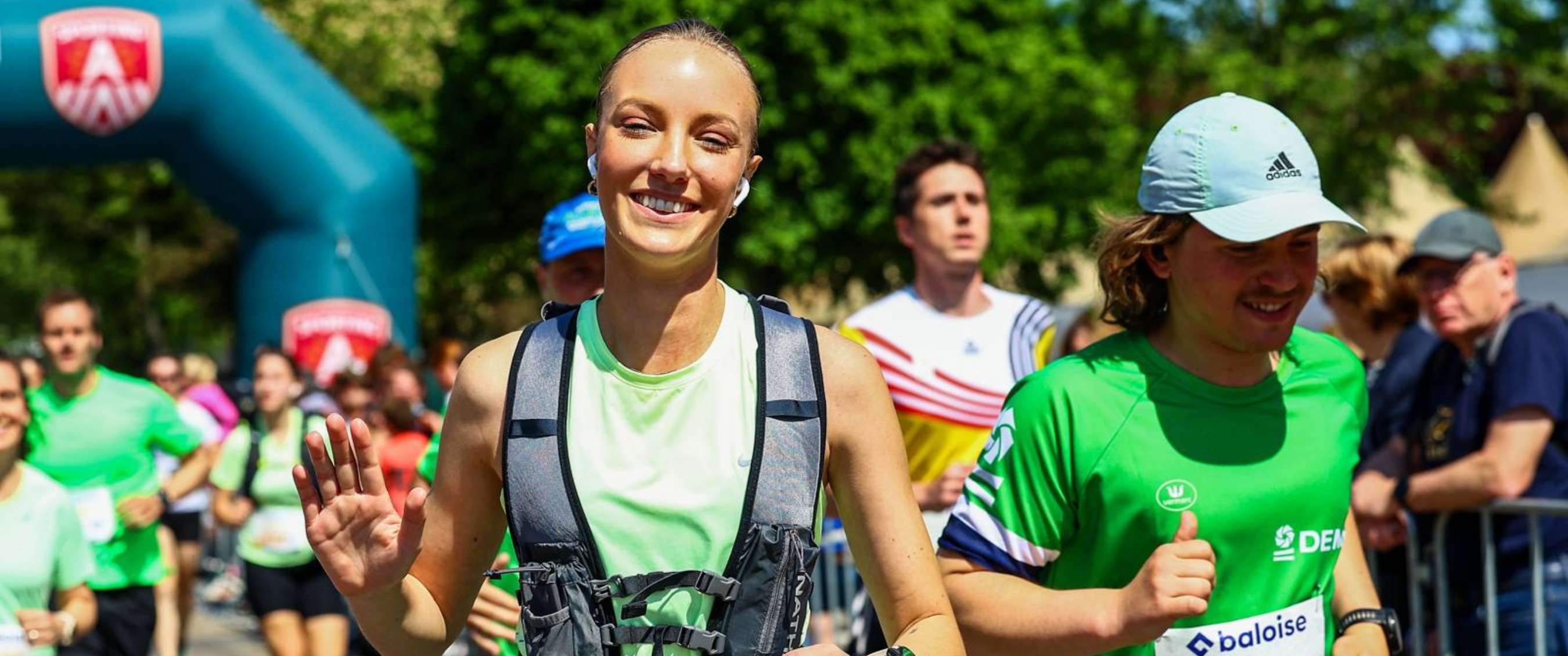 Coureurs sur le parcours avec dossard « baloise » et barrières visibles.