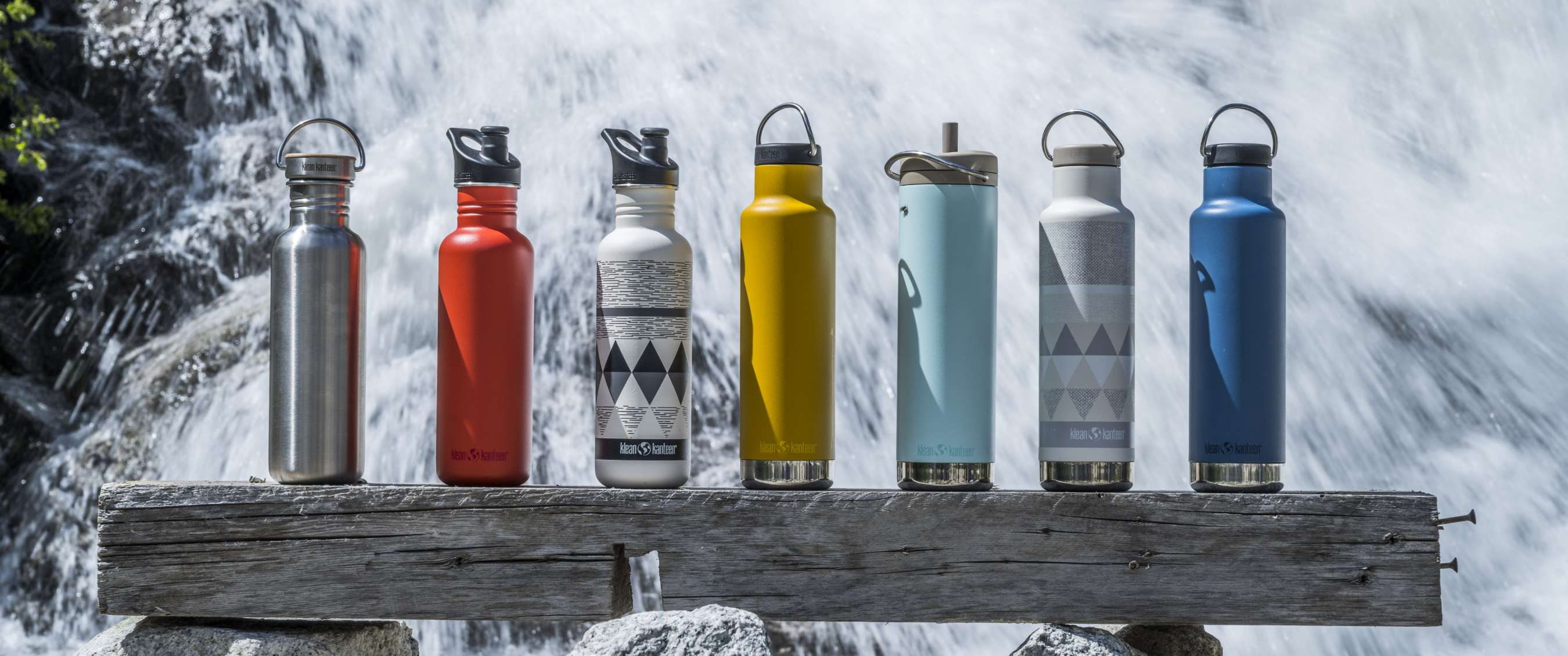 Gourdes de différentes couleurs sur une poutre avec de l’eau en mouvement en arrière-plan