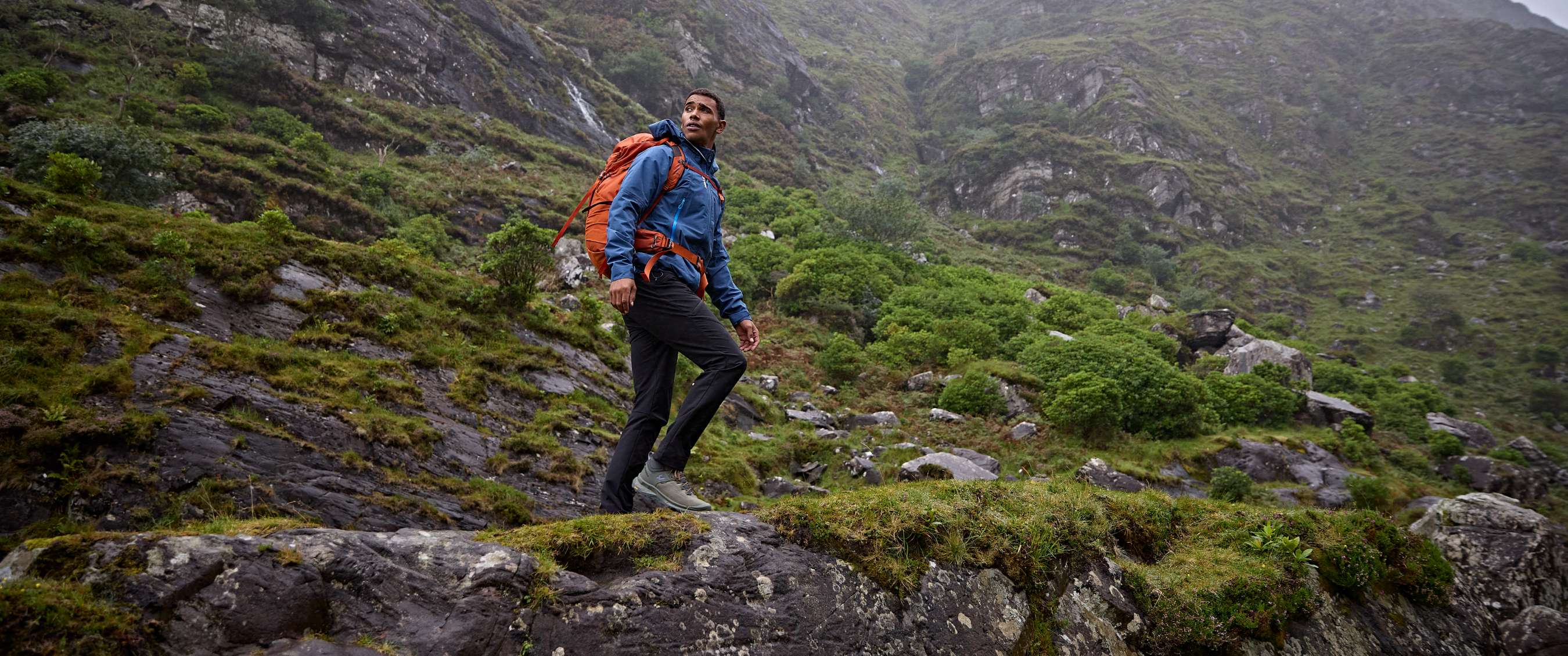 Randonneur en tenue outdoor dans un paysage de montagne